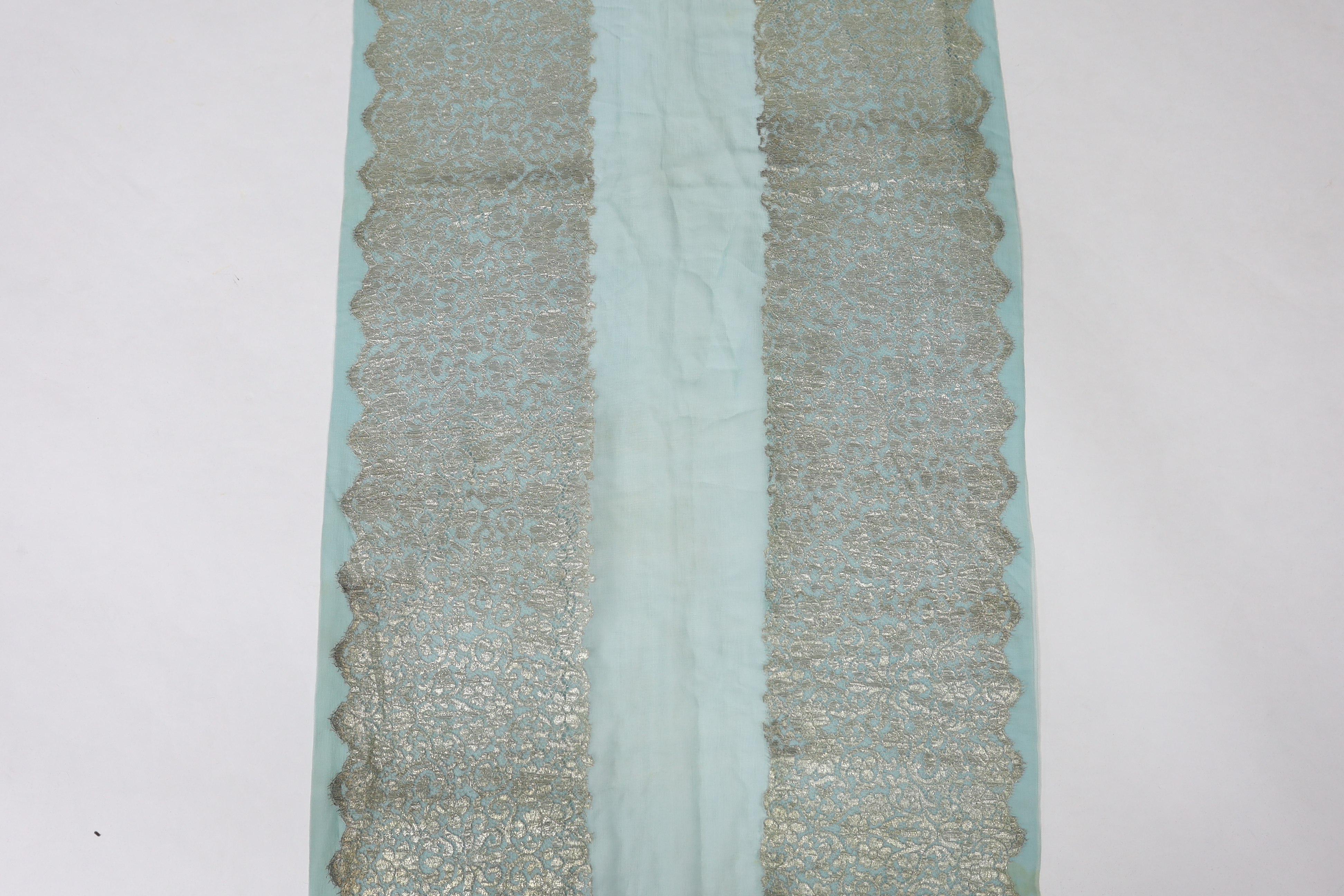 A 1920's silver machine lace and chiffon train, to an evening dress, the silver lace has been cut and appliquéd onto the turquoise chiffon, 209cm long